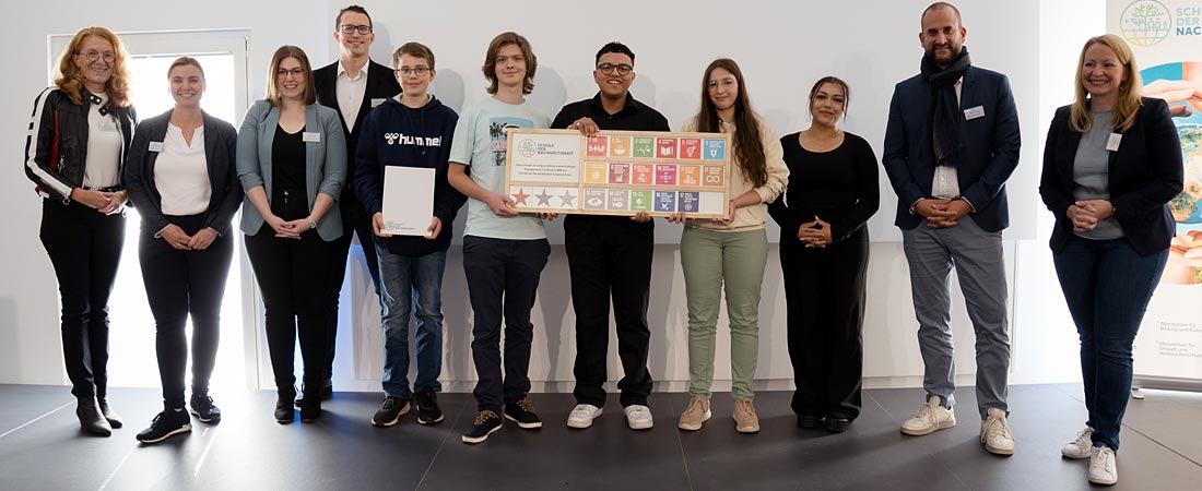 Snapshot in het kader van de netwerkbijeenkomst “Schule der Nachhaltigkeit” – te zien zijn scholieren die het kwaliteitskeurmerk in ontvangst nemen.